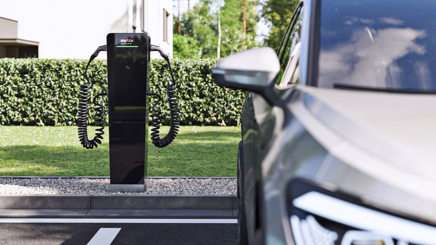 Ladesäule MyBox Post auf einem Parkplatz mit angeschlossenem Elektroauto